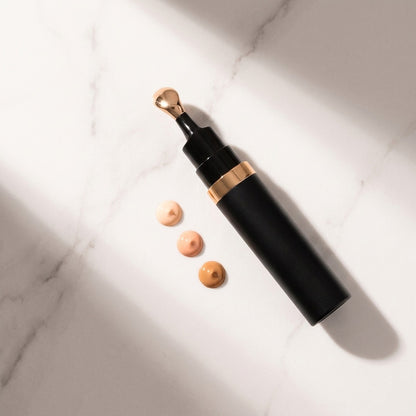 Corrector wand with three peach shades on marble